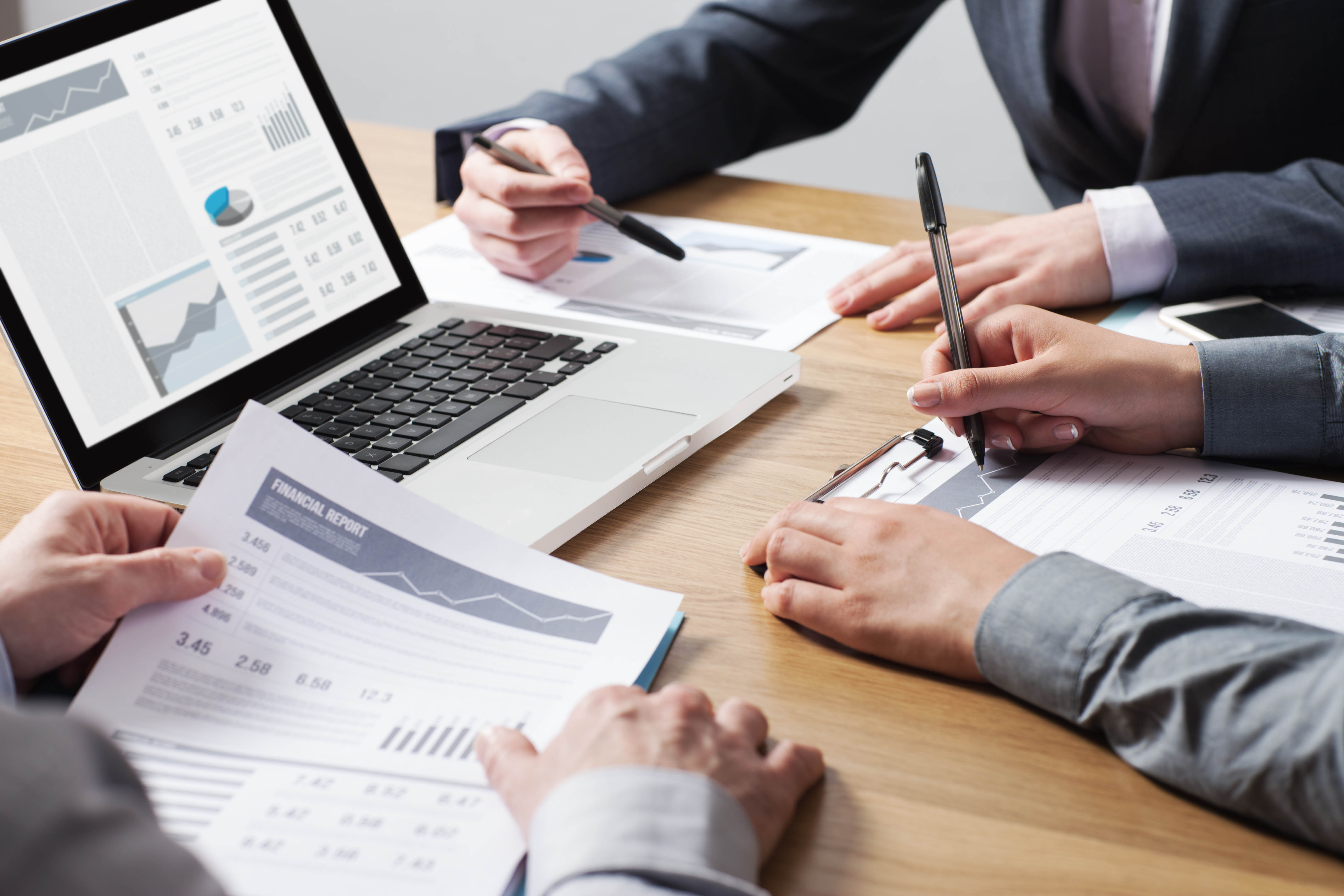 group of business professionals reviewing financial reports charts and graphs 